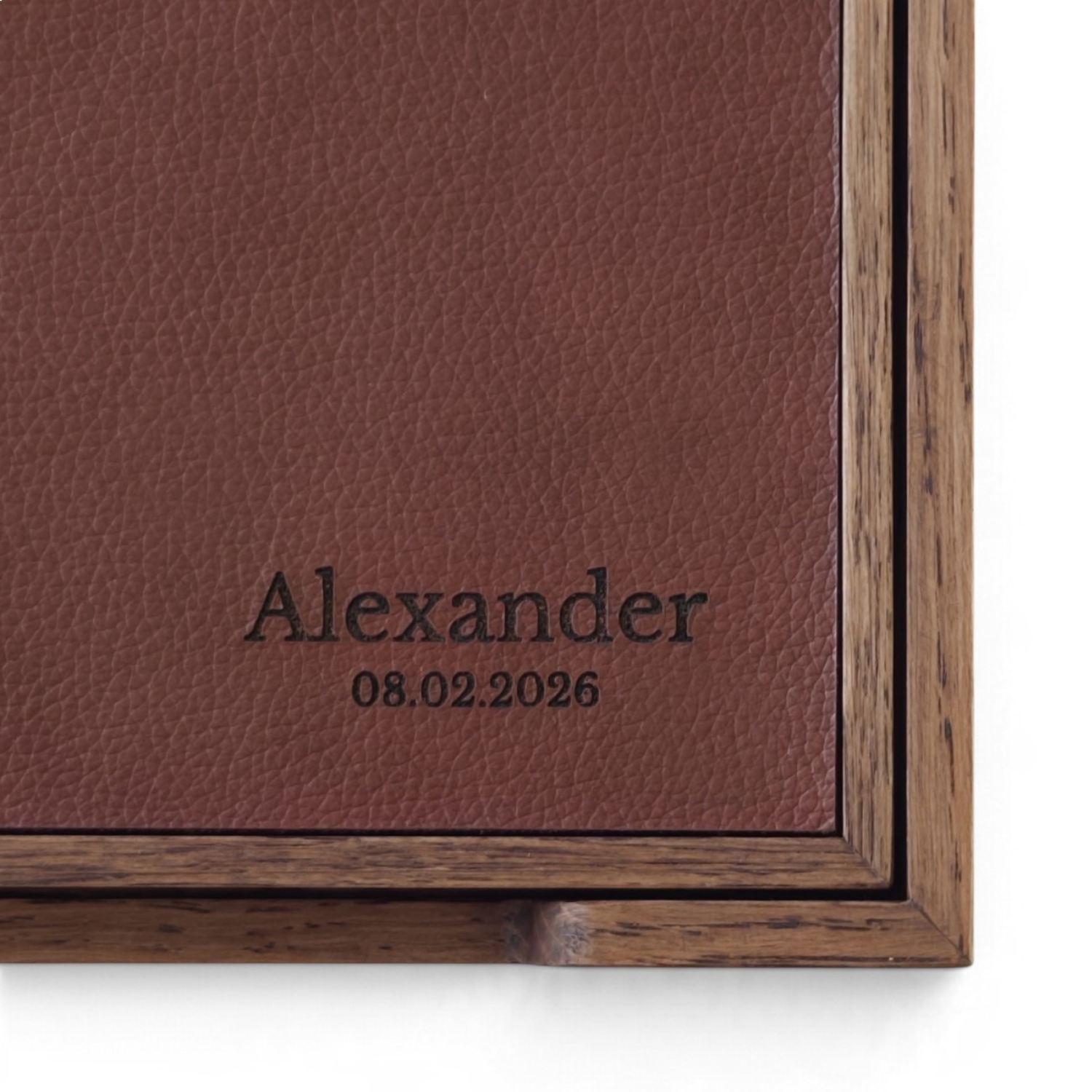 Navnet Alexander og datoen 08.02.2026 graveret på cognacfarvet læder i mørk træboks